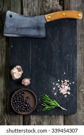 Old Cleaver (butcher Meat Knife) And Spices On Wooden Cutting Board, Texture Background. Cooking Ingredients. Copy Space. Mock Up For Cook Book