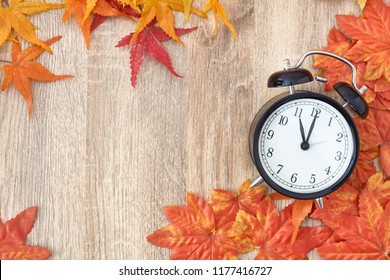Old Clock On Autumn Leaves On Wooden Table On Natural Background, Day Noon Light Blank Space For Text