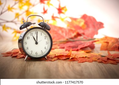 Old Clock On Autumn Leaves On Wooden Table On Natural Background, Day Noon Light Blank Space For Text