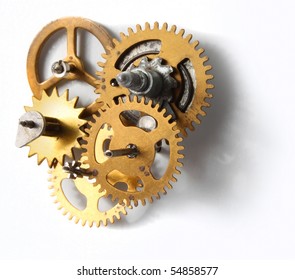 Old clockwork mechanism with brass metal cogs on white background