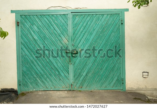 old\
closed wooden garage door painted with green\
paint