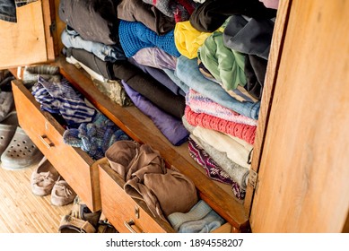 Old Clothes And Shoes In An Overflowing Closet. Second Hand Reuse. Decluttering And Cleaning The Cabinet. Second Hand Reuse. Decluttering And Cleaning The Cabinet