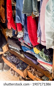 Old Clothes And Shoes In An Overflowing Closet. Second Hand Reuse. Decluttering And Cleaning The Cabinet. Second Hand Reuse. Decluttering And Cleaning The Cabinet