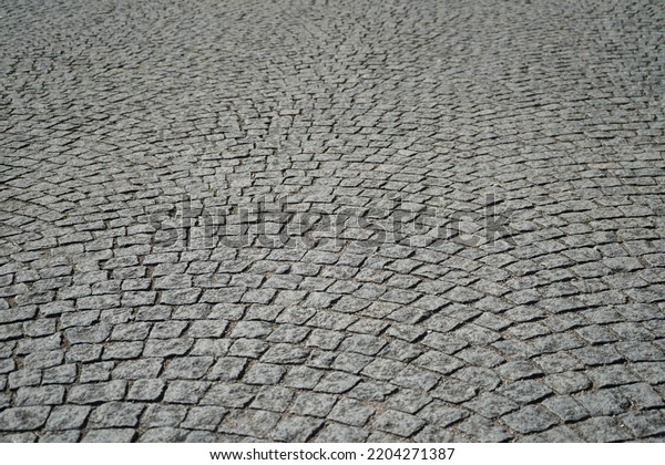 Old cobblestone pavement.\
Garden walk way, Parking floor background. Detail of granite\
sidewalk taken from above. Old street cobblestones for\
backdrop