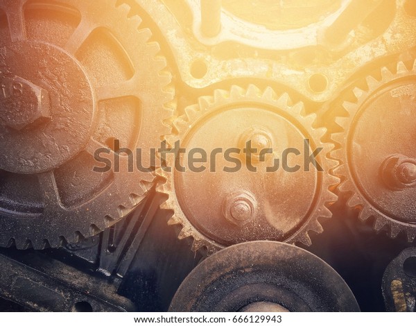 The old cogwheels join together background with\
sun flare effect.