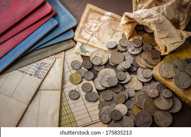 Old coins and bank book on grunge background.