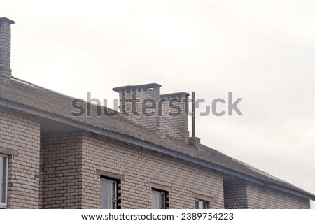 Old collapsing chimney on a red brick roof
