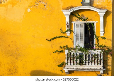 Old colonial balcony in a historic yellow building in Cartagena, Colombia