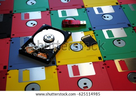 Old Colored Floppy disk with modern Hard Disk, Memory Pen USB and SD Memory Card. background