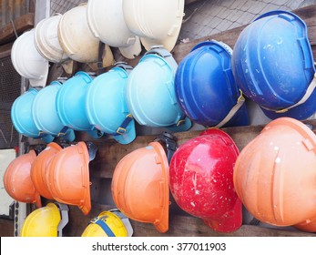 old colorful construction helmets on wood slat