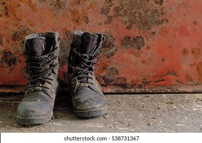 Old Combat Boot On Rusty Red Background