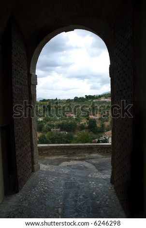 Old concrete archway with view out to Italian hillside village