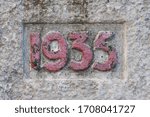 Old concrete bas-relief on the wall, numer 1935