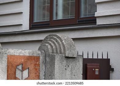 An Old Concrete Fence Post With A Semi-circular Decoration On Top