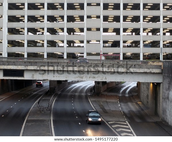 an old\
concrete multistory car park build over an underpass on an inner\
city ring road with traffic in leeds\
center