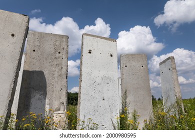 Old concrete slabs standing on a summer sunny day in the field. Old unfinished building