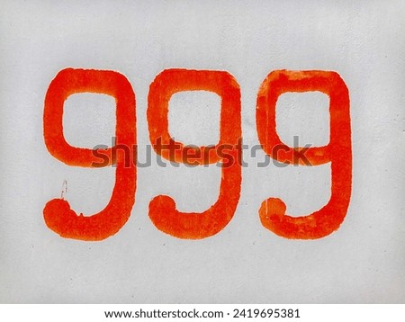 old concrete wall with red number 999 close up
