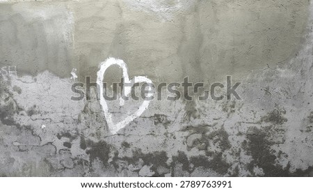Old concrete wall with rough texture and simple drawn white heart symbol