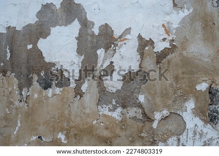 Old concrete wall with worn out limewash peeling plaster 