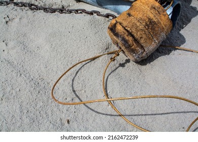 old cork float for fishing boat and iron chain, lie on the sand