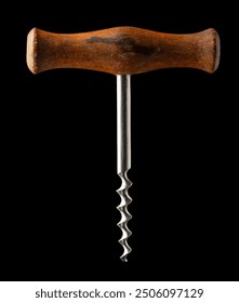 Old corkscrew with wooden handle isolated on a black background.