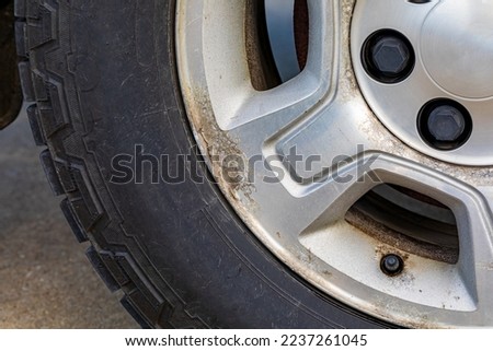Old, corroded aluminum wheel on vehicle. Automobile maintenance repair and car care concept.