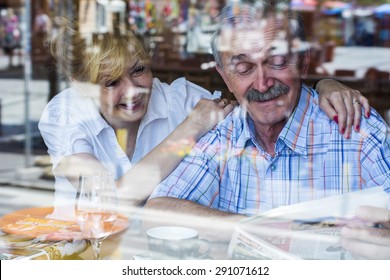 An Old Couple In A Cafe Reading 