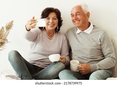 Old Couple Drinking Coffee And Taking Selfie Photos With Smartphone.