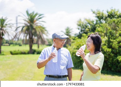 Old Couple Drinking Water Outside