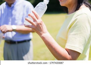 Old Couple Drinking Water Outside