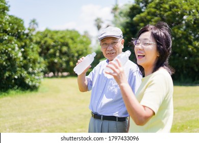 Old Couple Drinking Water Outside