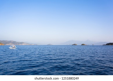 Old Couple Fishing With Small Fishing Boat On Blue Sea