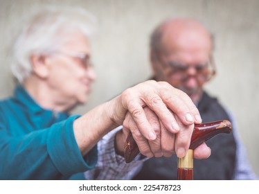 old couple. old man an woman still together holding each other hands over the man cane - Powered by Shutterstock