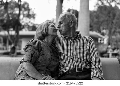 Old Couple In A Park About To Kiss