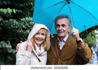 The old couple in the rain with umbrellas  - Powered by Shutterstock