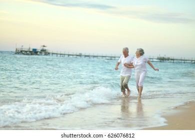 Old Couple Running On Sea Beach