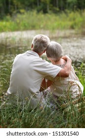 Old Couple Sitting Near Lake