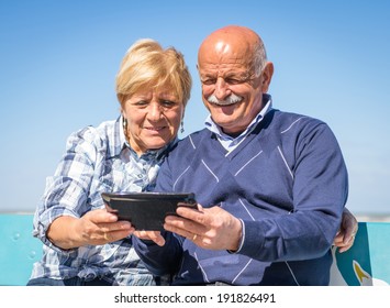 Old Couple Watching Photos On A Tablet