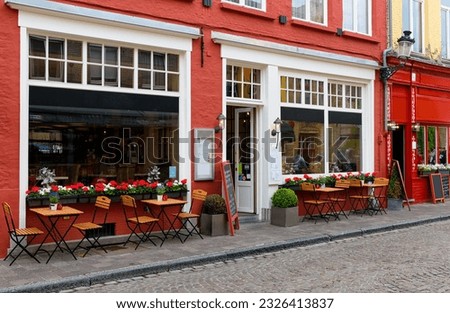 Old cozy street with tables of restaurant in Bruges (Brugge), West Flanders province, Belgium. Cityscape of Bruges.