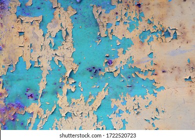 Old cracked and partially peeled paint of green, blue, violet, red, gray color on metal surface close-up. Protection, aging and corrosion of metal. Application of paint in several layers.