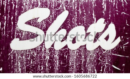Old cracked vinyl Shots lettering sign. Damaged peeling letters display