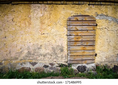 Old Cracked Yellow Wall With Boarded Up Doors