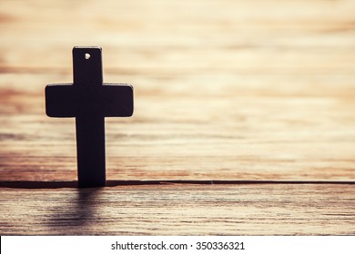 Old cross on a brown wood background 