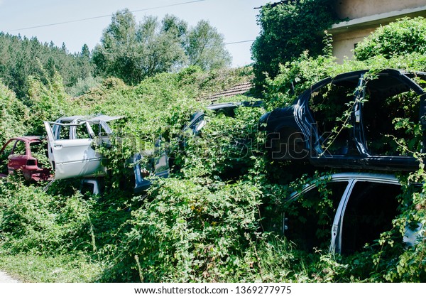 Old crushed cars bodies stored in auto\
wrecking junk yard for scrap and spare\
parts
