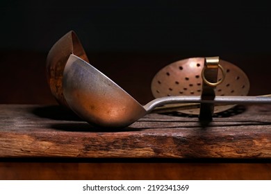 Old Culinary Kitchen Utensils. Aged Ladles And Skimmer On Rustic Wood Base And In Low Key