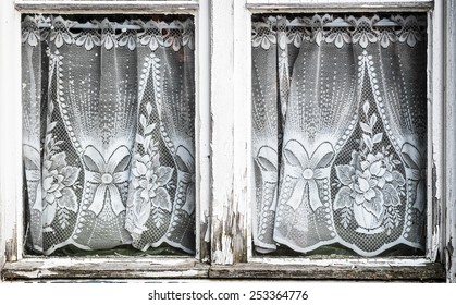 Old Curtains At A Rundown Window