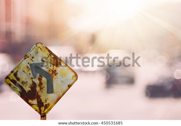 Old curve road\
warning sign on blur traffic road with colorful bokeh light\
abstract background. Copy space of transportation and travel\
concept. Retro tone filter color\
style.