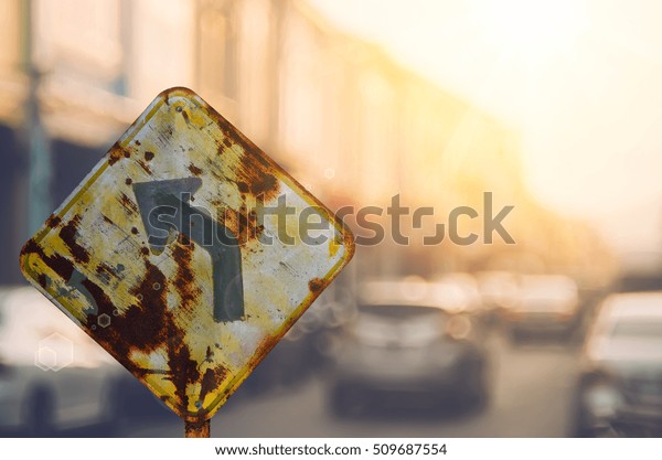 Old
curve road warning sign on blur traffic road with colorful bokeh
light abstract background. Copy space of transportation and travel
adventure concept. Retro tone filter color
style.