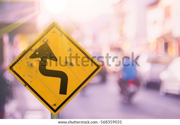 Old curve road
warning sign on blur traffic road with colorful bokeh light
abstract background. Copy space of transportation and travel
concept. Retro tone filter color
style.