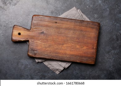 Old cutting board over towel on stone kitchen table. Top view flat lay with copy space